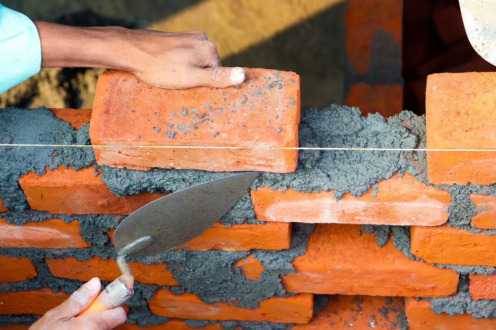 Bricklayer laying bricks — a West Midlands trades business we support