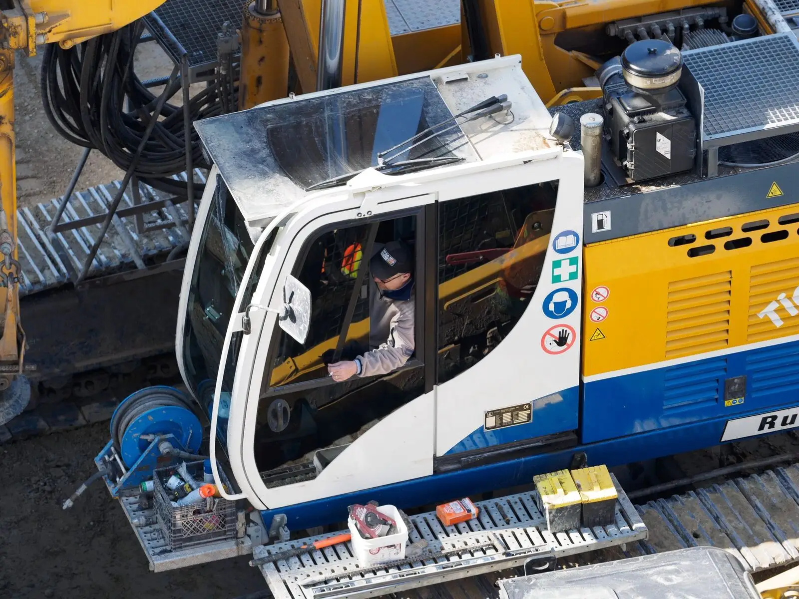 Digger driver operating an excavator on site — a West Midlands trades business we support