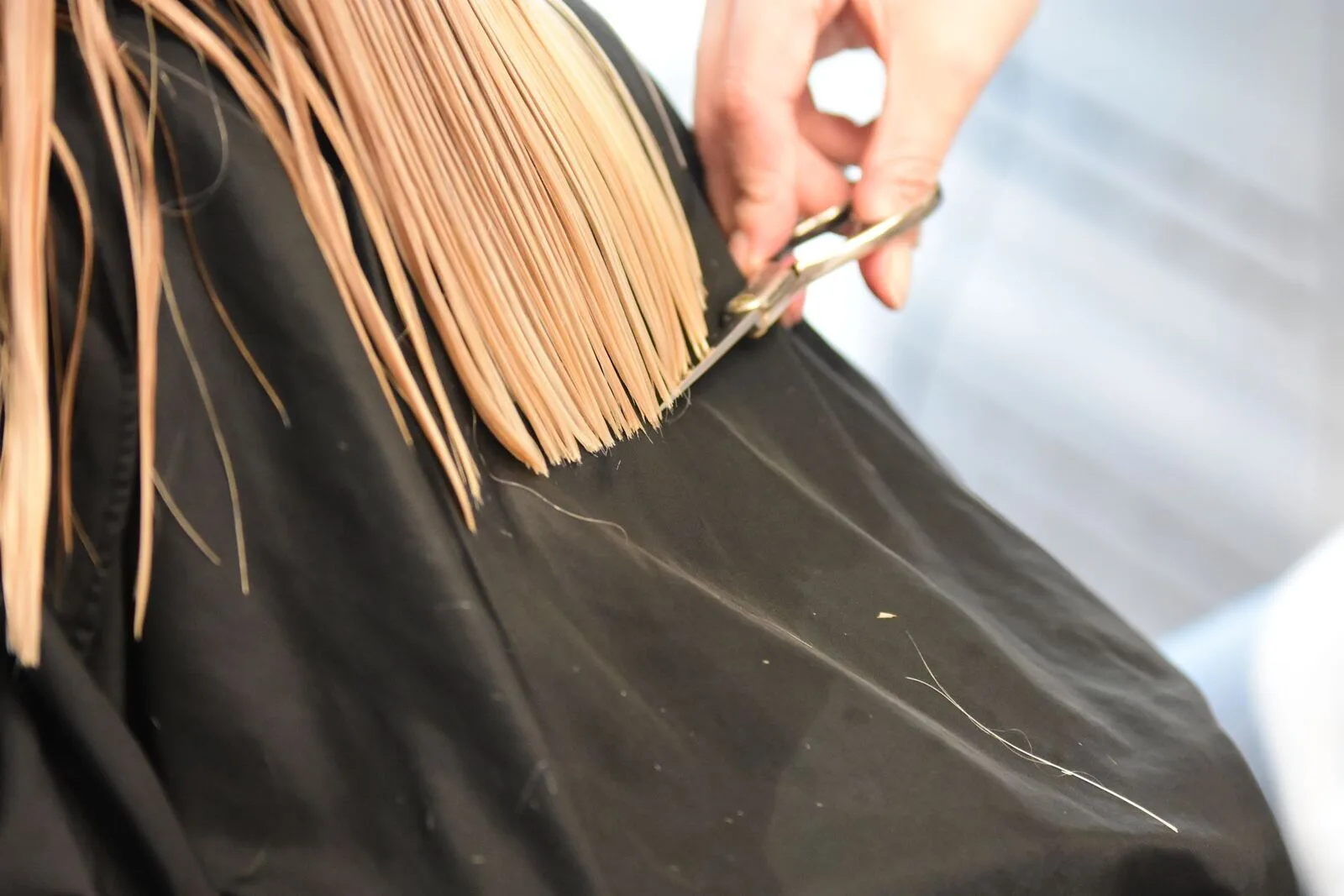 Hairdresser cutting a client's hair in a salon — a West Midlands trades business we support