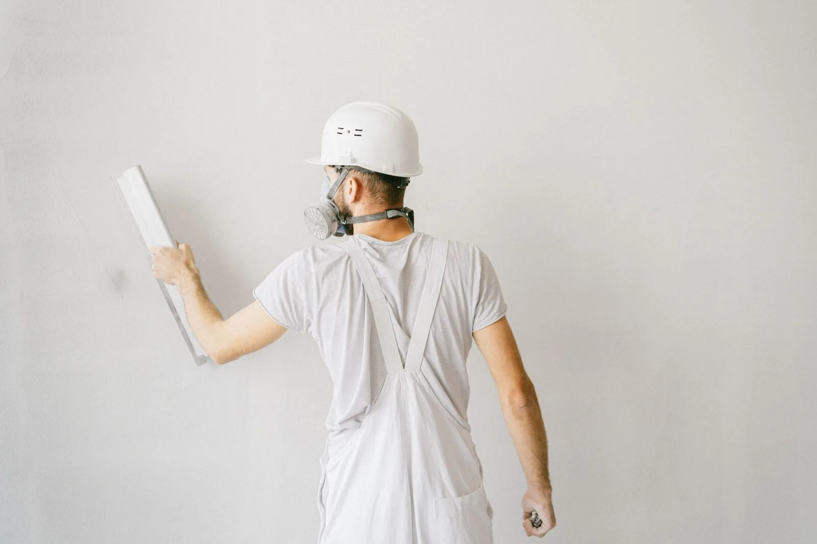 Plasterer applying fresh plaster to a wall — a West Midlands trades business we support