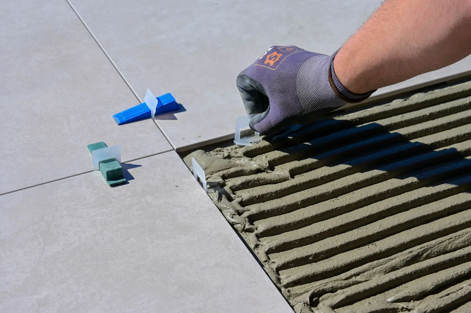 Tiler laying floor tiles — a West Midlands trades business we support
